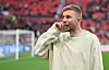 Christoph Kramer am Spielfeldrand im Stadion, im Hintergrund das Fußballfeld und rote Zuschauerränge.