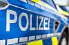 Schriftzug «Polizei» an der Tür eines blau-weißen Streifenwagens.