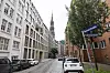 Katharinenstraße in Hamburg mit Straßenschild, geparkten Autos und Kirchturmspitze im Hintergrund.