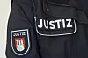 Dunkle Justiz-Uniform mit Hamburger Wappen und weißer Aufschrift »JUSTIZ«