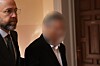 Anwalt Björn Kruse begleitet seinen Mandanten David Barkay durch einen Flur im Landgericht Hamburg.