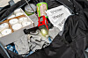 Gepackter Notfallrucksack mit Wasser, Kerzen, Kleidung und Kurbelradio als Krisenvorsorge.