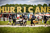 Festivalbesucher tragen Gepäck zum Zeltplatz des Hurricane-Festivals, im Hintergrund der große HURRICANE-Schriftzug.