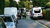 Polizei und Rettungskräfte sichern eine Unfallstelle in einer Wohnstraße mit Absperrband und Einsatzfahrzeugen.