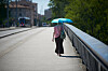 Frau mit Sonnenschirm geht auf einer Brücke in Toulouse bei großer Hitze.