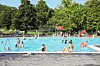 Besucher entspannen und schwimmen im Außenbecken.