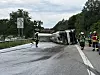 Umgekippter Milchlaster auf der A261 bei Hamburg, Feuerwehrleute sichern die Unfallstelle auf der Brücke.