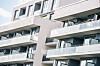 Modernes Mehrfamilienhaus in Berlin mit weißen Balkonen und großen Glasflächen.