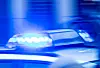 Blaulicht eines fahrenden Einsatzfahrzeugs in verschwommener Nahaufnahme.