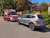 Silberner SUV am Straßenrand, dahinter ein Rettungswagen auf einer ruhigen Wohnstraße.