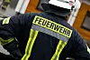 Feuerwehrmann mit Helm und „Feuerwehr“-Schriftzug im Einsatz in Osnabrück.