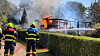 Feuerwehrleute löschen eine in Flammen stehende Laube in einer Kleingartenanlage in Barsbüttel.