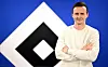Claus Costa steht vor dem HSV-Logo mit verschränkten Armen in Hamburg.