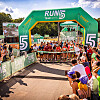 Läufer warten unter einem RUN5-Startbogen auf den Start.