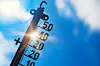 Thermometer vor strahlender Sonne zeigt hohe Temperaturen und Hitzewelle.