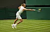 Alexander Zverev in Weiß schlägt bei Wimbledon einen Ball auf dem Rasenplatz.