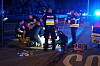 Polizei und Rettungskräfte arbeiten nachts an einer abgesperrten Unfallstelle mit Blaulicht.