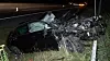 Schwer beschädigter Skoda nach Überschlag im Graben an der A7, Rettungskräfte vor Ort.