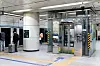 Glasaufzug an der U-Bahnstation neben taktilem Leitsystem und gelb-schwarzen Sicherheitsmarkierungen.