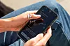 Hand hält Smartphone mit Aktienkursverlauf auf dem Display.