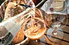 Mineralwasser wird zu Weißwein ins Glas gegossen, daneben Brot und weitere Gläser.