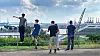Vier Personen schauen von Altonaer Balkon auf Hafenkräne und Schiffe.