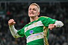 Tomas Bobcek jubelt im grünen Trikot von Lechia Danzig vor dunklem Stadionhintergrund.