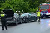 Einsatzkräfte sichern eine Unfallstelle mit beschädigten Autos auf nasser Straße ab.