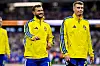 Jesper Karlstrom und Eric Smith von Schweden wärmen sich in gelben Trainingsjacken auf dem Rasen auf.