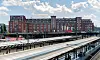 Ehemaliges Bahnpostamt am Hühnerposten in Hamburg mit markanter Backsteinfassade und Bahnsteigen im Vordergrund.