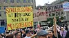 Menschen bei einer Kundgebung halten Protestschilder zu Schulbegleitung und gefährdeten Kindern in die Höhe.
