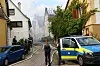 Polizei und Feuerwehr sichern eine Wohnstraße nach einem Brand in einem Wohnhaus.