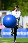 Merlin Polzin trainiert mit dem Hamburger SV auf dem Platz und bewegt einen großen blauen Ball.