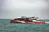 Roter Katamaran Halunder Jet der FRS Helgoline fährt durch raue See bei Sturm
