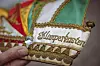 Verzierte Narrenkappe mit goldener Stickerei und Klimperkasten in einer Hand auf dem Flohmarkt.