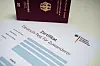 Deutscher Reisepass neben Zertifikat „Deutsch-Test für Zuwanderer“ auf hellem Untergrund.