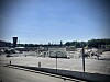 Weite Abrissfläche mit Bauschutt, Containergebäude und Stadt skyline im Hintergrund