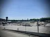 Weite Abrissfläche mit Bauschutt, Containergebäude und Stadt skyline im Hintergrund