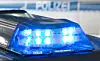 Blau blinkendes Blaulicht auf einem Polizeifahrzeug vor unscharfem Polizeihintergrund.