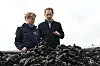 Cornelia Schmachtenberg und Torben Wagner stehen auf einem Muschelkutter vor einem Haufen Muscheln.