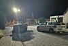 Unfallstelle bei Nacht mit zwei beschädigten Autos auf einer schmalen Straße, Einsatzkräfte im Hintergrund.