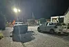 Unfallstelle bei Nacht mit zwei beschädigten Autos auf einer schmalen Straße, Einsatzkräfte im Hintergrund.