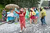 Teilnehmer des Schlagermove in Regenjacken und mit Schirmen auf der Helgoländer Allee in Hamburg.