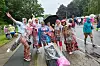 Teilnehmer des Schlagermove stehen mit Regenschirmen und Regencapes auf der Helgoländer Allee in Hamburg.