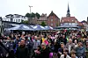 Menschenmenge beim Trauermarsch in Stade vor Marktständen und historischen Häusern.