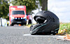 Motorradhelm auf der Straße, im Hintergrund ein Rettungswagen nach einem Unfall auf der K 204.