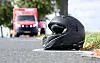 Motorradhelm auf der Straße, im Hintergrund ein Rettungswagen nach einem Unfall auf der K 204.