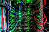 Serverrack eines Hochleistungsrechners mit Kabeln und leuchtenden Status-LEDs.