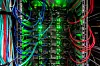 Serverrack eines Hochleistungsrechners mit Kabeln und leuchtenden Status-LEDs.