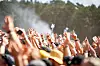 Publikum reckt bei einem Musikfestival die Arme vor der Bühne in die Luft.